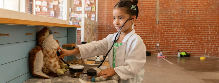 Child plays veterinarian with stuffed animal