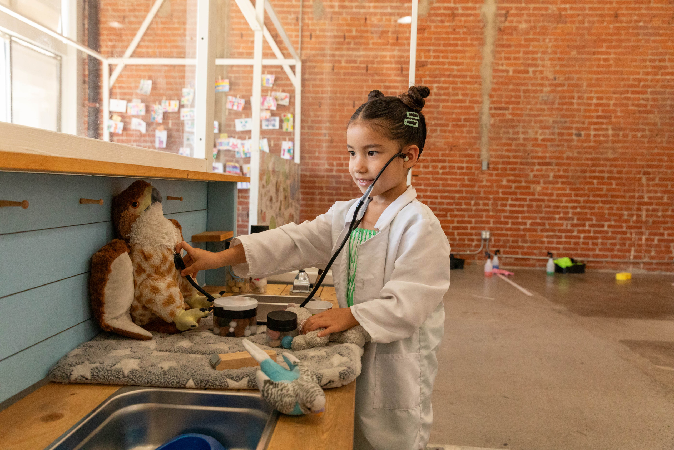Child plays veterinarian with stuffed animal